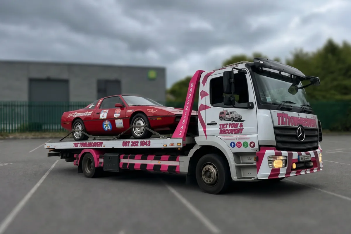 T1T tow truck transporting a car on a recovery bed